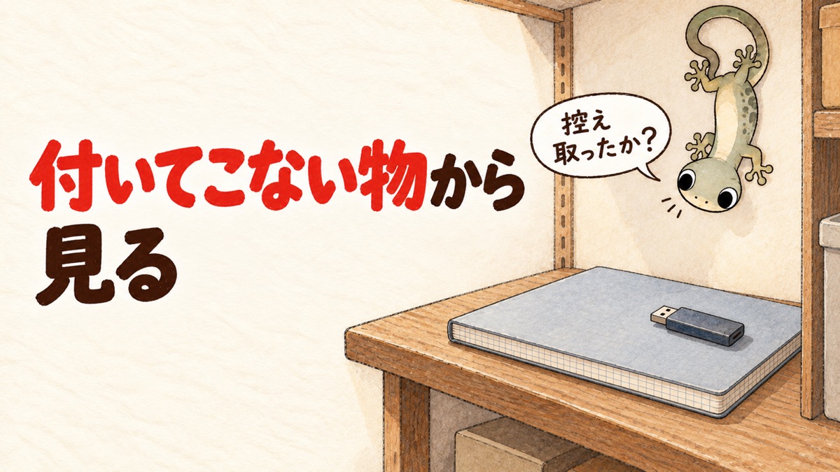 納戸の壁のヤモリと、USBメモリを1本のせた閉じたノート